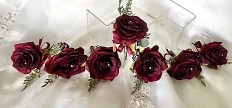 Bouquet of burgundy roses with greenery on a white lace background
