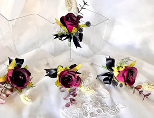 Three floral hair accessories with pink and black flowers on a white lace background