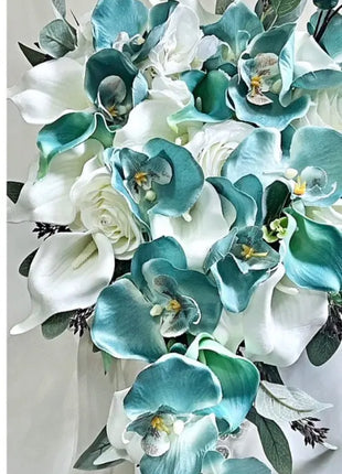 Bouquet of turquoise and white flowers with greenery on a light gray background