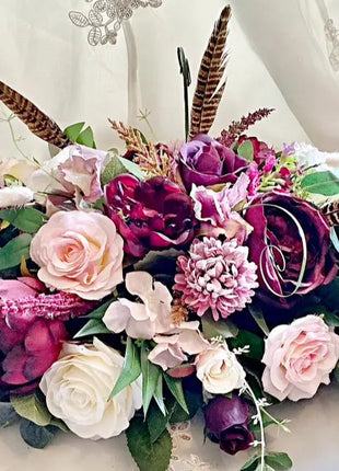 Scottish Table Arrangement with roses pheasant feather In plum Beaux Faux Flowers Shop