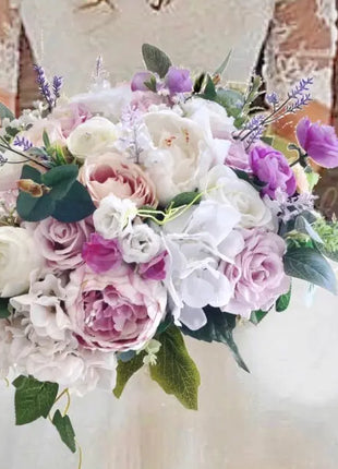 Bouquet of flowers with white, pink, and purple colors held by a person wearing a lace dress.