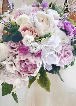 Bouquet of pink, white, and purple flowers with green leaves on a blurred background