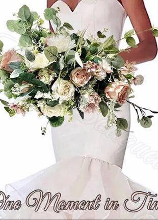 Bouquet of flowers held by a person wearing a white dress with 'One Moment in Time' text.