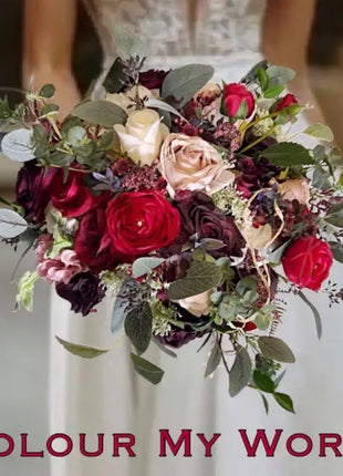 Bouquet of red, burgundy, and white flowers held by a person wearing a white dress with 'Colour My World' text.