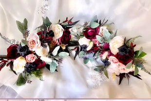 Decorative floral arrangement with red, pink, and white flowers on a white background