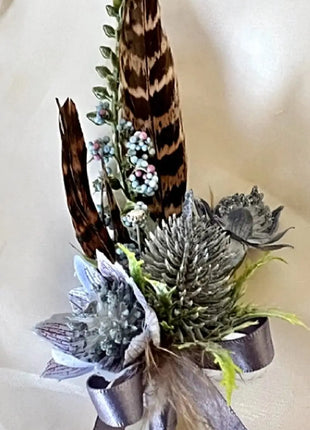 Gents, guest buttonhole with Dusty blue eryngium thistle and pheasant feather detail Beaux Faux Flowers Shop