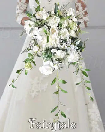 Bouquet of white flowers with green leaves held by a person, with 'Fairytale' branding.