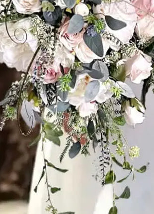 Floral arrangement with pink and white flowers and greenery in a vase.