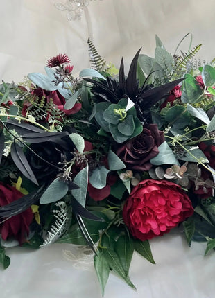 Floral silk  arrangement  in black and red on a white  fabric background with intricate details