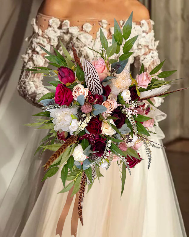 Bouquet of flowers held by a person wearing a floral dress.