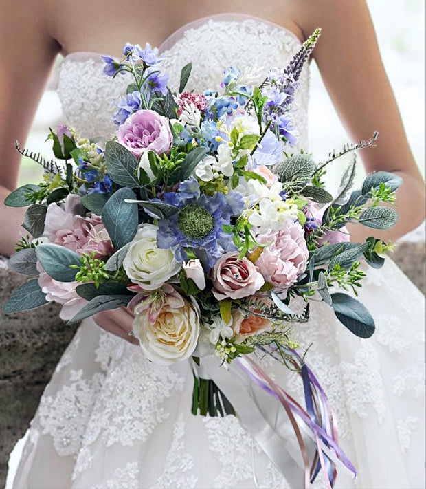 Bouquet of flowers held by a person wearing a white lace dress.