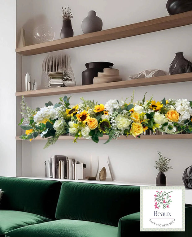 Floral arrangement on a shelf above a green sofa with decorative items.